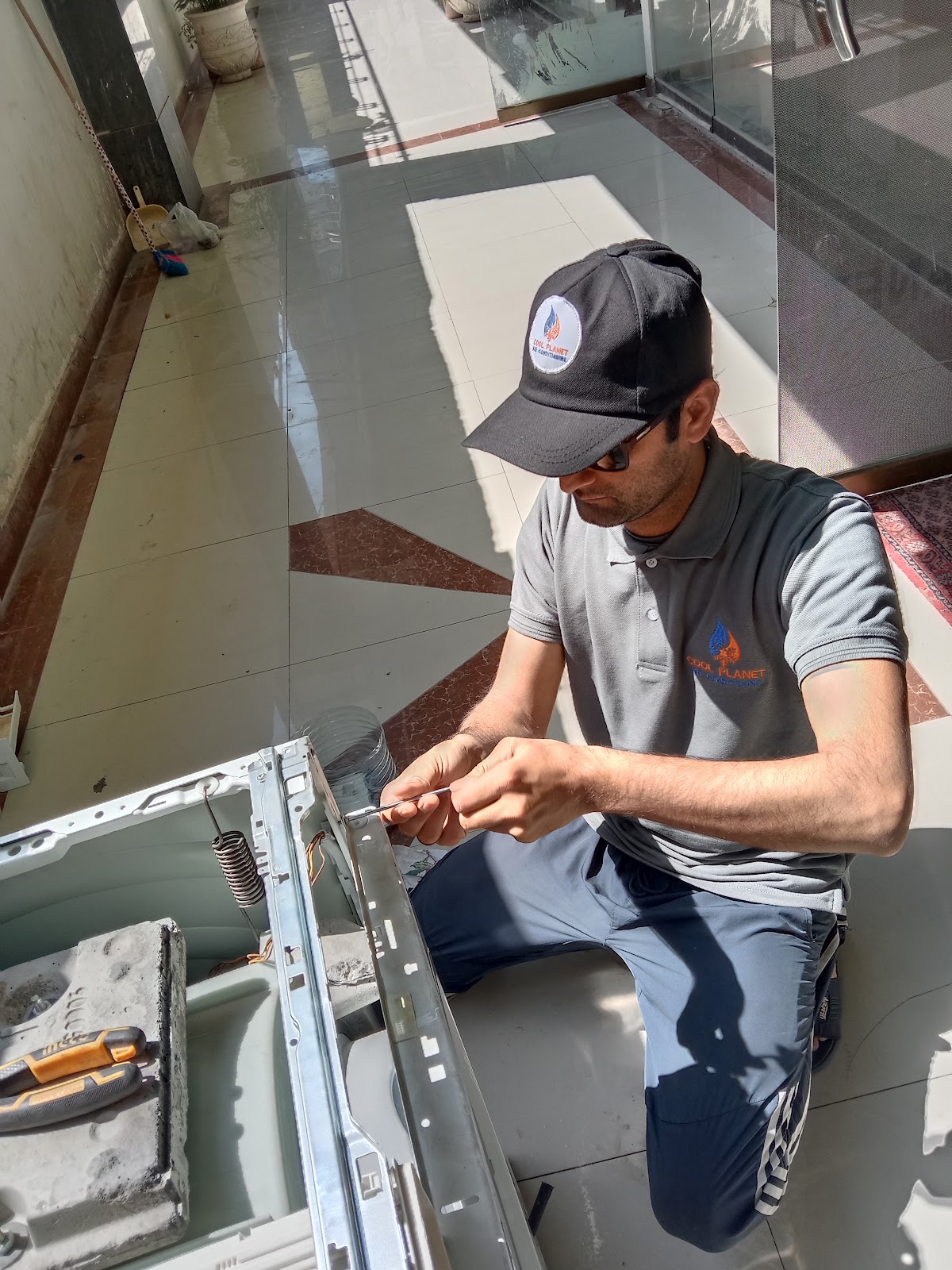 Cool Planet technician repairing an indoor split AC