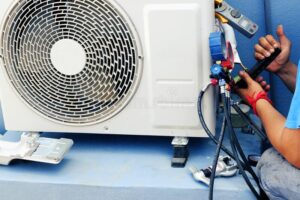 Air Conditioning Technician is Repairing Air Conditioner ,because of Leakage of Air Solution at the Pipe Joint Stock Image